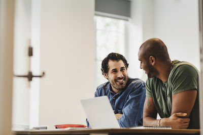 Smiling friends talking while sitting in language class