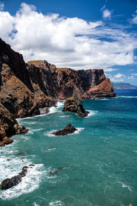 Scenic view of rocks in sea against sky