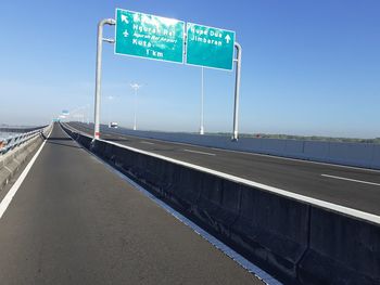 Road sign against clear blue sky