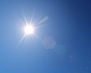 Low angle view of moon in blue sky