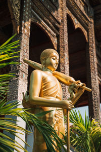 Statue of angel outside temple against building