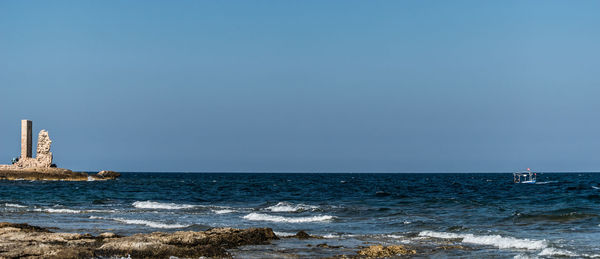 Scenic view of sea against clear blue sky