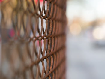 Close-up of chain hanging on metal fence