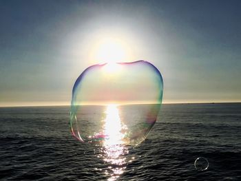 Close-up of bubbles against sea during sunset
