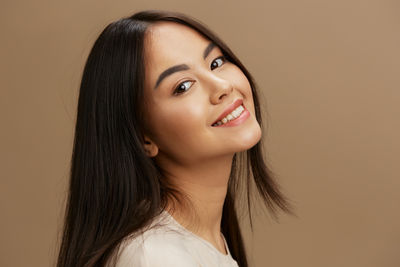 Portrait of young woman against pink background