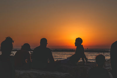 Silhouette people on beach during sunset