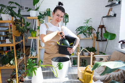 Portrait of young woman using mobile phone while sitting on table