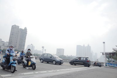 Vehicles on road against buildings in city