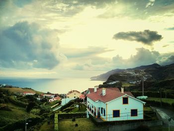 Houses in town against cloudy sky