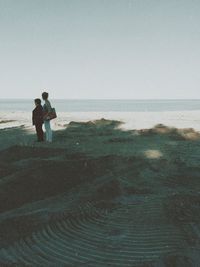 People looking at sea against sky