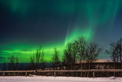 Snow covered landscape against sky at night