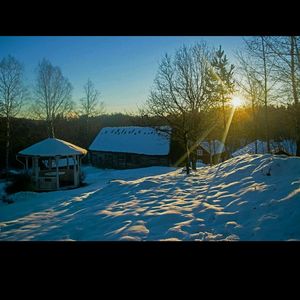 Snow covered landscape with houses in background