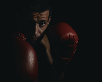 Close-up portrait of boxer against black background