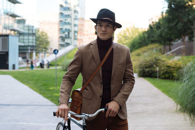 Portrait of young man riding bicycle in city