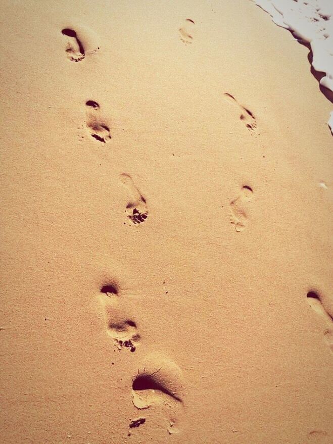 HIGH ANGLE VIEW OF FOOTPRINTS ON BEACH