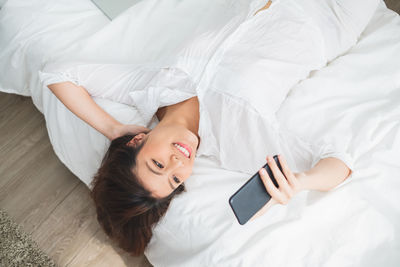 High angle view of woman lying on bed at home