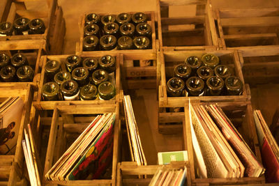 High angle view of wine bottles and books in wooden crates