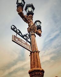 Low angle view of sign board against sky