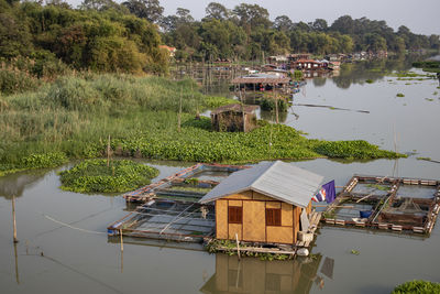 Houses by lake against trees