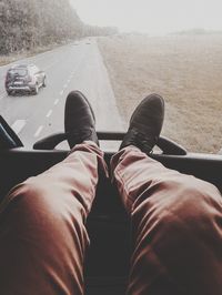 Low section of man relaxing on road