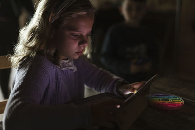 Girl using tablet pc at table in home