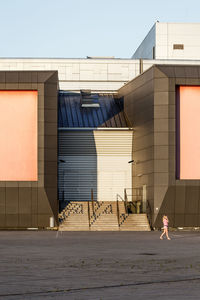 Woman walking on street outside buildings