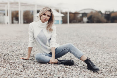 Portrait of young woman sitting on road