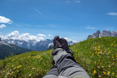 Low section of person on mountain against sky