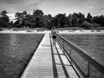 People on shore against sky