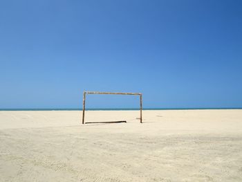 View of goal post on beach against sky