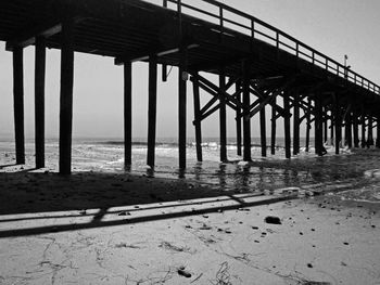 Silhouette built structure on beach against sky