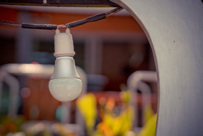 Close-up of electric lamp hanging on metal