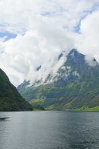 Scenic view of mountains and sea against cloudy sky