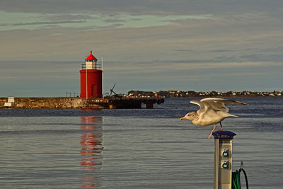 View of lighthouse by sea against sky