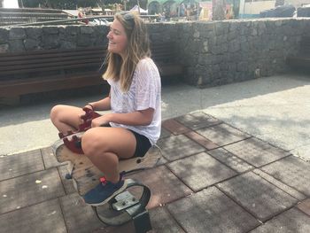 Woman sitting on outdoor play equipment at playground