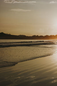 Scenic view of beach against sky during sunset