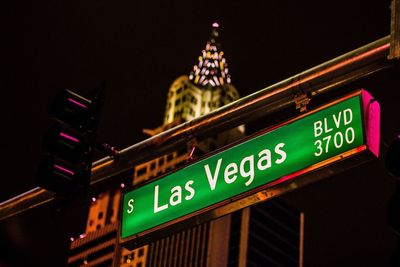 Low angle view of illuminated text on building at night