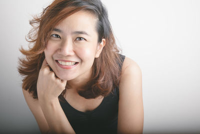 Portrait of a smiling young woman over white background