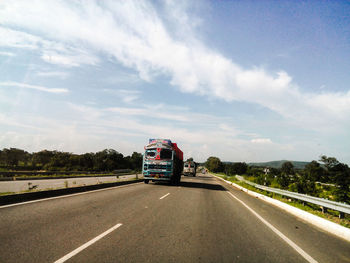 Semi-trucks on highway against sky