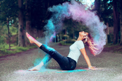 Side view of woman exercising in forest