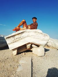 Couple sitting against clear sky