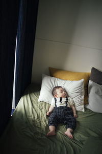 Boy sitting on bed at home