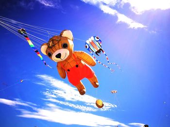 Low angle view of toy flying against blue sky