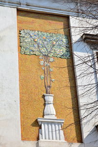 Low angle view of bare tree against building