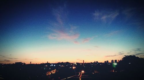 Silhouette city against sky at sunset