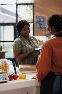 Side view of young woman sitting on table