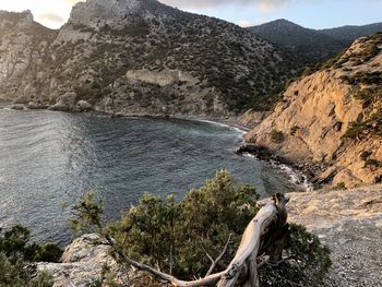 Scenic view of rocks by sea against mountain