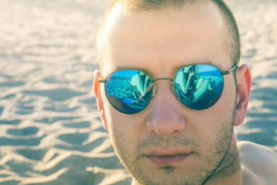 Close-up portrait of man wearing sunglasses at beach during sunny day