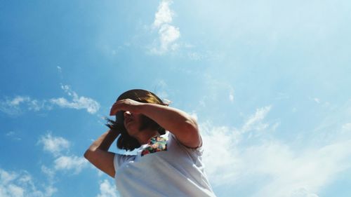 Low angle view of woman standing against sky