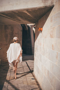 Rear view of woman walking on wall